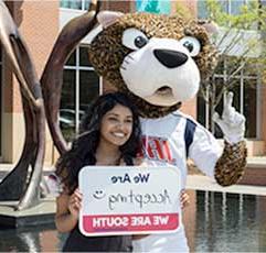 SouthPaw and a USA Student hold a sign that states: We Are Accepting